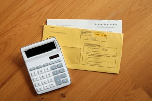 Sitzen Sie mit dem Handy zwischen Ohr und Schulter am Steuer, müssen Sie mit einem Bußgeld rechnen.