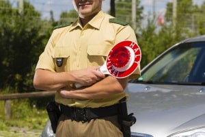 Der Polizist regelt den Verkehr mit Handzeichen, obwohl die Ampel intakt ist? Die Polizei hat Vorrang!